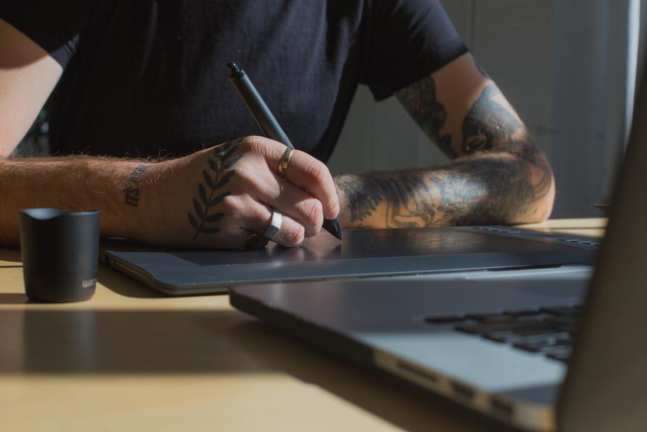 A man sitting at a table using a laptop computer